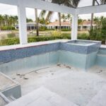 Empty pool and spa area at a luxury home renovation project in Miromar Lakes, Florida