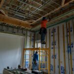Construction crew working on ceiling and wall systems inside a luxury home renovation in Miromar Lakes, Florida