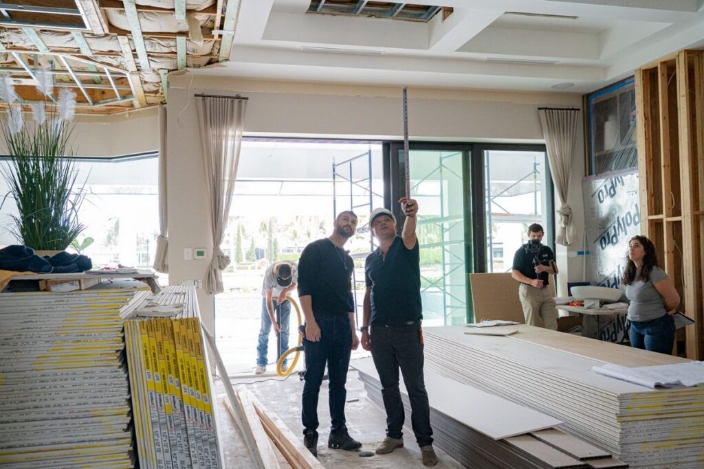 Project team reviewing ceiling layout and interior renovation progress inside a luxury home in Miromar Lakes, Florida