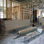 Wide interior view of open framing, stacked drywall, and renovation materials inside a luxury home in Miromar Lakes, Florida