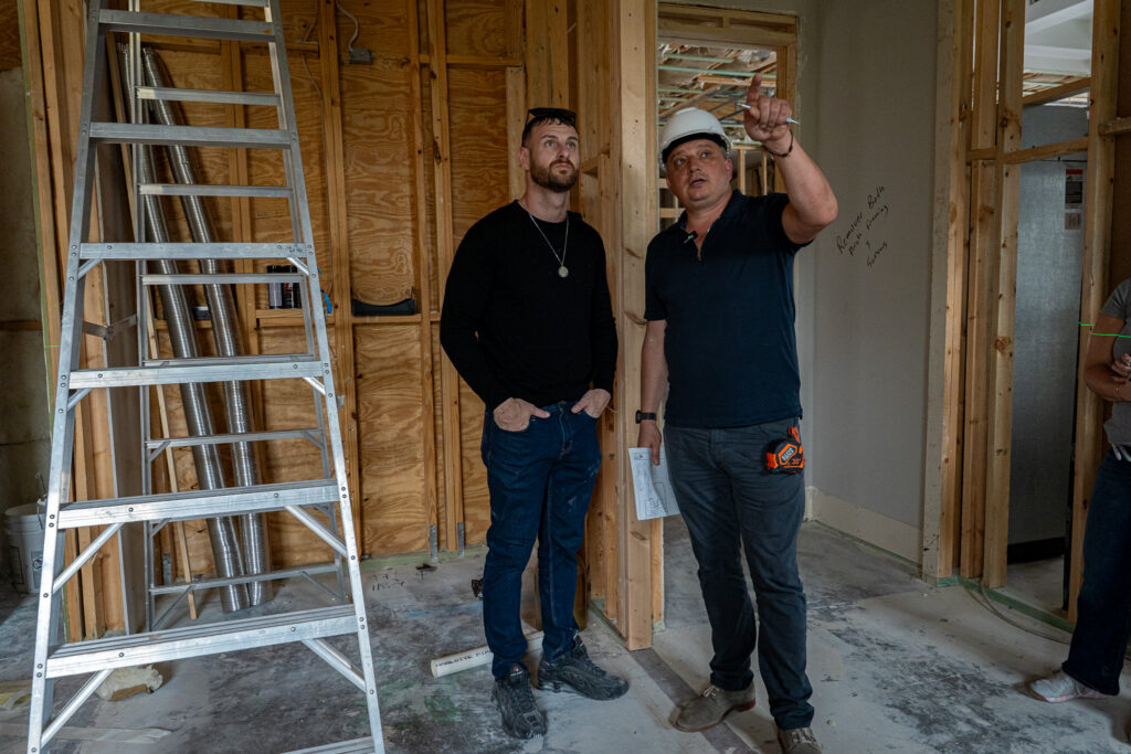 Contractor and homeowner reviewing electrical and remodeling plans inside a home renovation project in Southwest Florida.