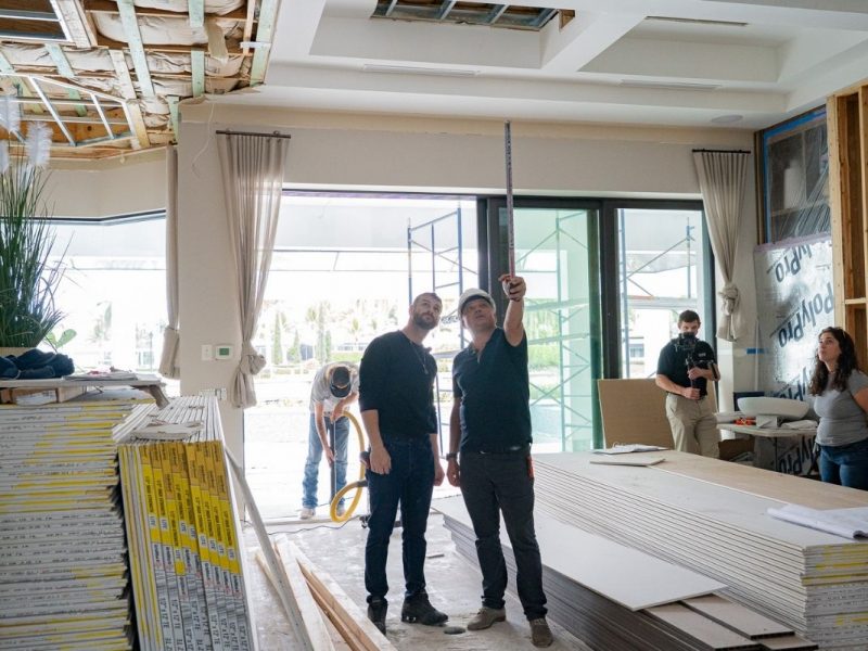 Project team reviewing ceiling layout and interior renovation progress inside a luxury home in Miromar Lakes, Florida